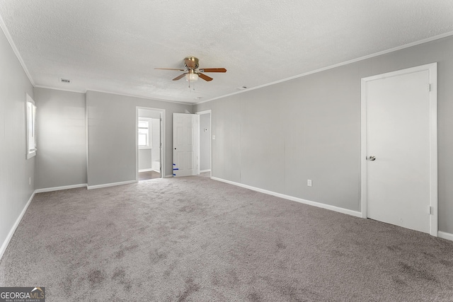 spare room featuring ceiling fan, a textured ceiling, carpet floors, and crown molding