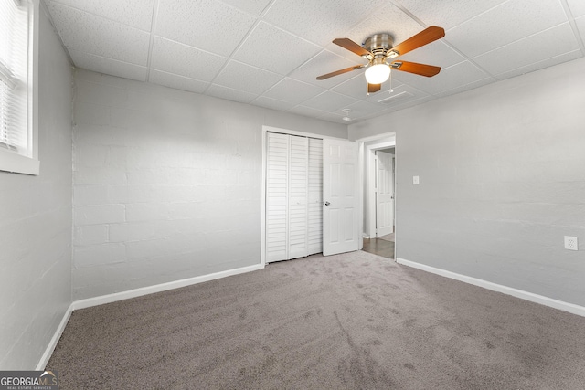 unfurnished bedroom featuring ceiling fan, carpet, and a paneled ceiling