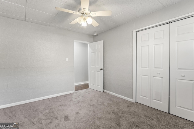 unfurnished bedroom featuring ceiling fan, carpet, and a closet