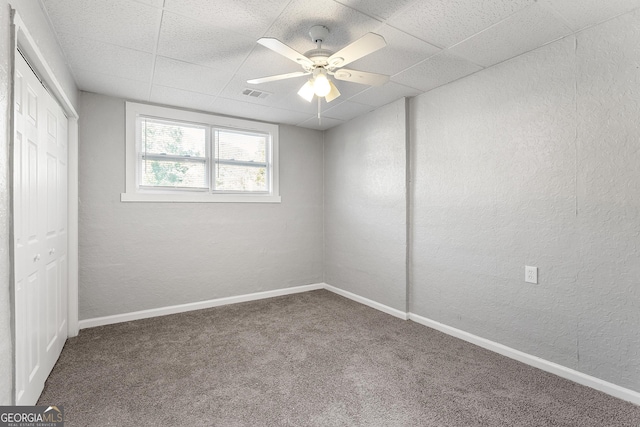 spare room featuring carpet floors, a drop ceiling, and ceiling fan