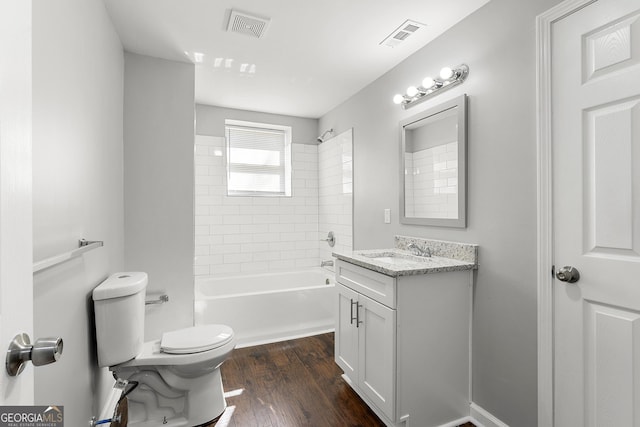 full bathroom with hardwood / wood-style flooring, toilet, vanity, and tiled shower / bath