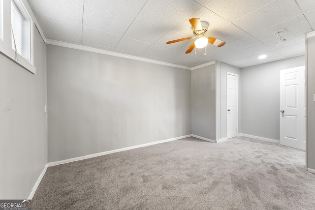 unfurnished room with ceiling fan, a drop ceiling, crown molding, and carpet flooring