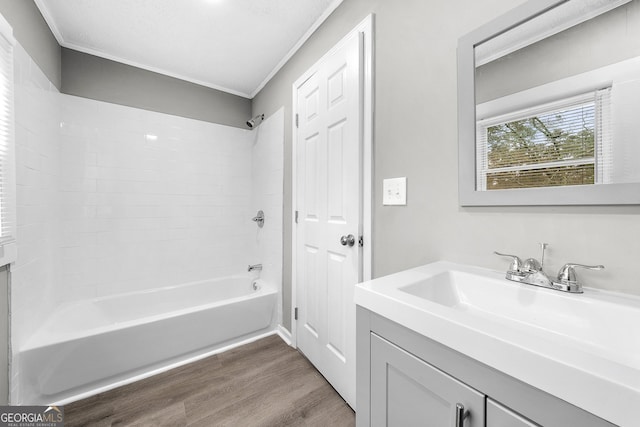 bathroom with tub / shower combination, wood-type flooring, vanity, and crown molding