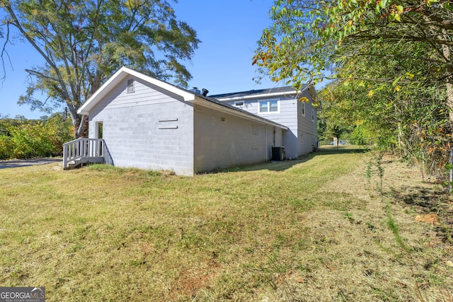 view of home's exterior featuring cooling unit and a lawn