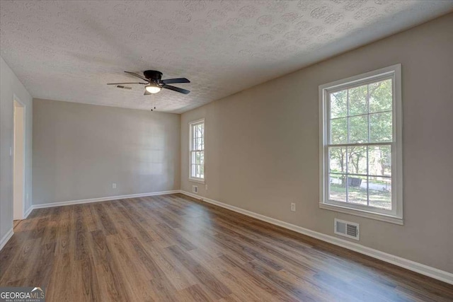 unfurnished room featuring hardwood / wood-style flooring, ceiling fan, and a textured ceiling