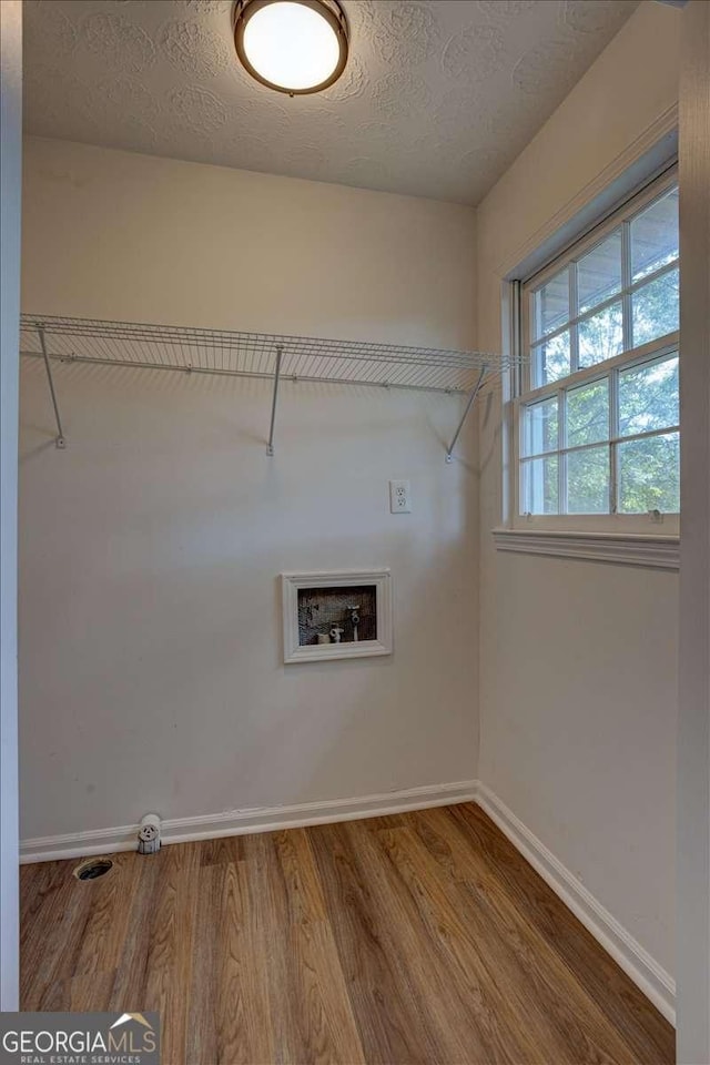 laundry area featuring hardwood / wood-style flooring, washer hookup, and a textured ceiling