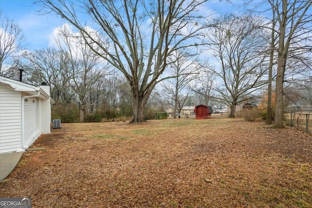 view of yard featuring central AC and a storage unit