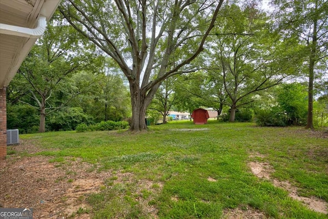 view of yard with central AC and a storage shed