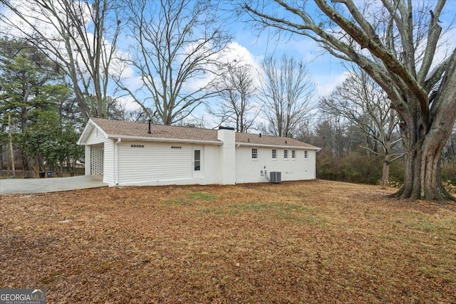 back of property with a lawn and a carport