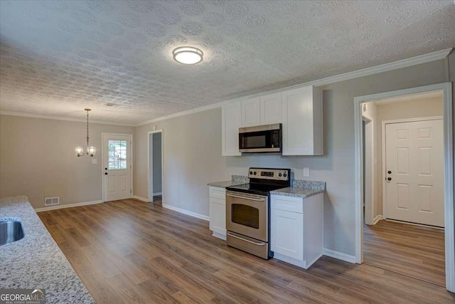 kitchen featuring white cabinetry, stainless steel appliances, light hardwood / wood-style floors, and hanging light fixtures