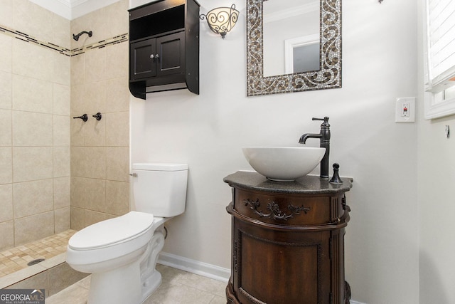 bathroom featuring tile patterned flooring, a tile shower, vanity, ornamental molding, and toilet