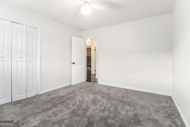 unfurnished bedroom with dark carpet, a closet, and ceiling fan