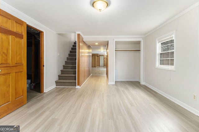 interior space with light hardwood / wood-style floors, ornamental molding, and a closet