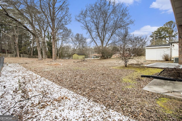 view of yard featuring central AC unit and a shed