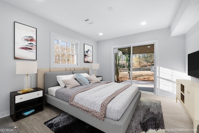 bedroom featuring access to exterior and light wood-type flooring