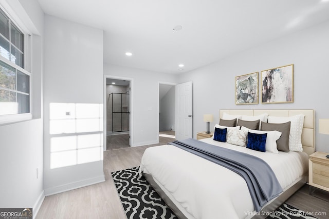 bedroom featuring ensuite bathroom and hardwood / wood-style floors