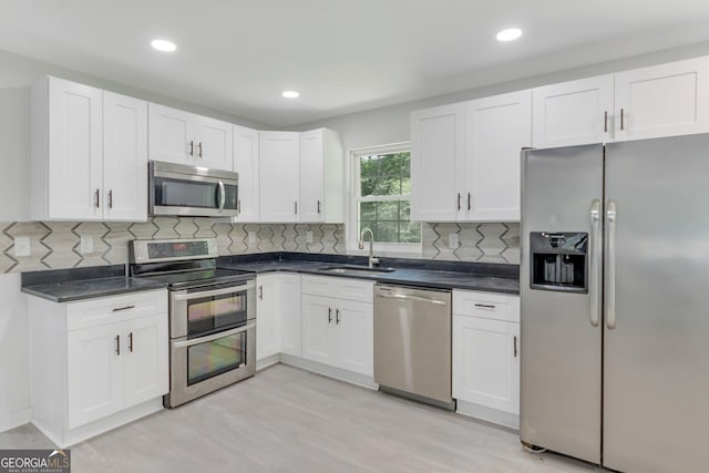 kitchen with white cabinetry, sink, light hardwood / wood-style flooring, and stainless steel appliances