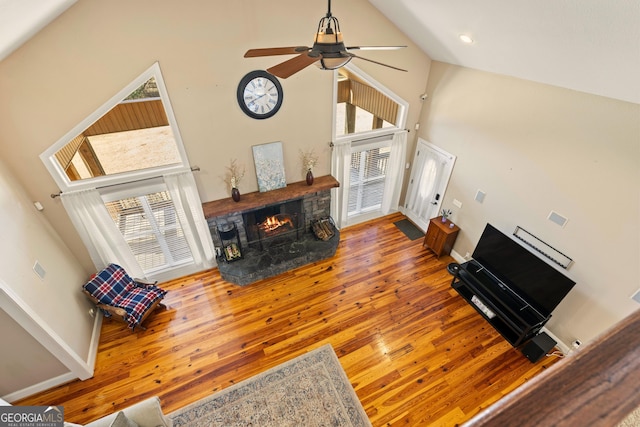 living room featuring hardwood / wood-style flooring, a towering ceiling, and a healthy amount of sunlight