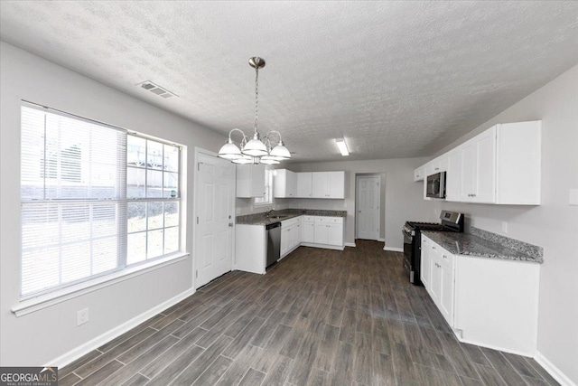 kitchen featuring decorative light fixtures, white cabinets, stainless steel appliances, and an inviting chandelier