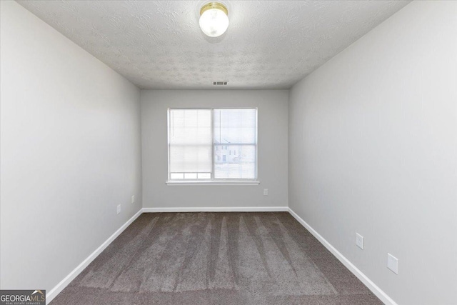 carpeted spare room featuring a textured ceiling