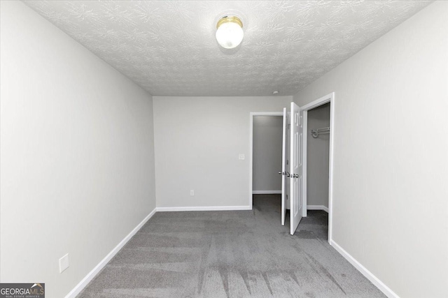 unfurnished bedroom with a textured ceiling, a closet, and carpet flooring