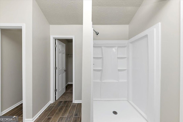 bathroom featuring a textured ceiling and walk in shower