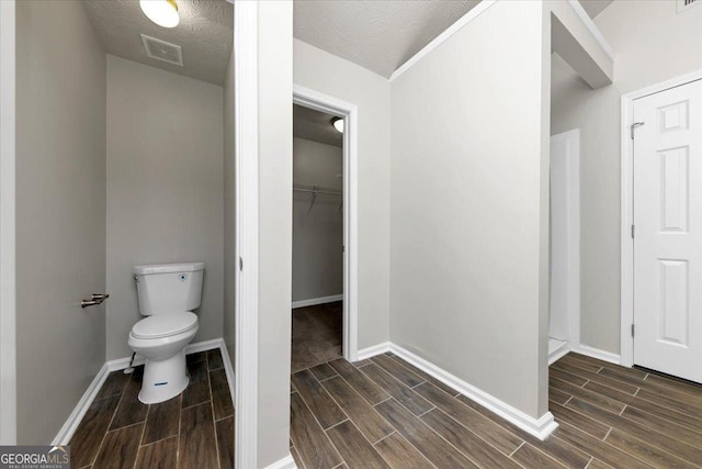 bathroom with a textured ceiling and toilet