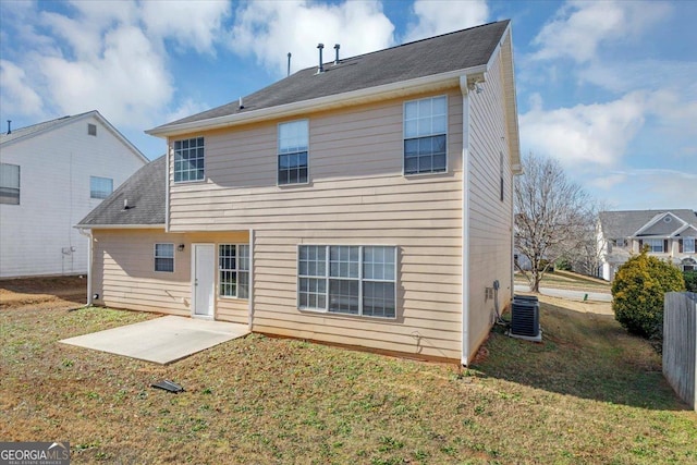 rear view of house featuring a lawn, central AC unit, and a patio