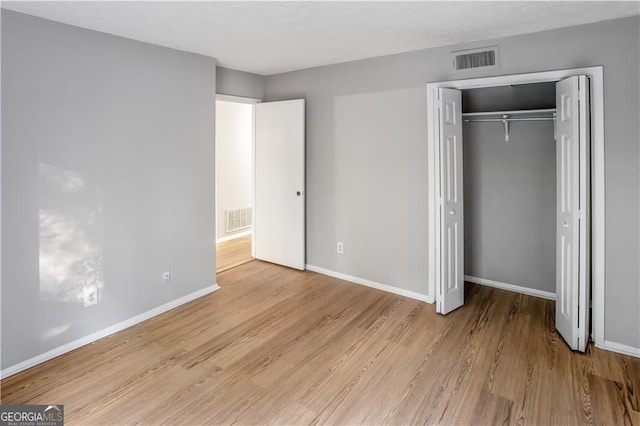 unfurnished bedroom with a closet and light hardwood / wood-style flooring