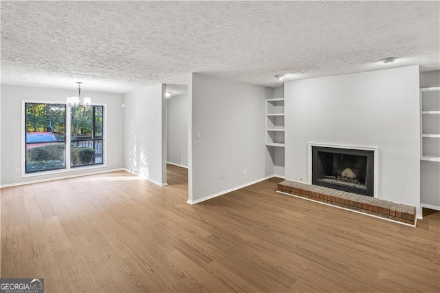 unfurnished living room with hardwood / wood-style floors, a textured ceiling, and a notable chandelier