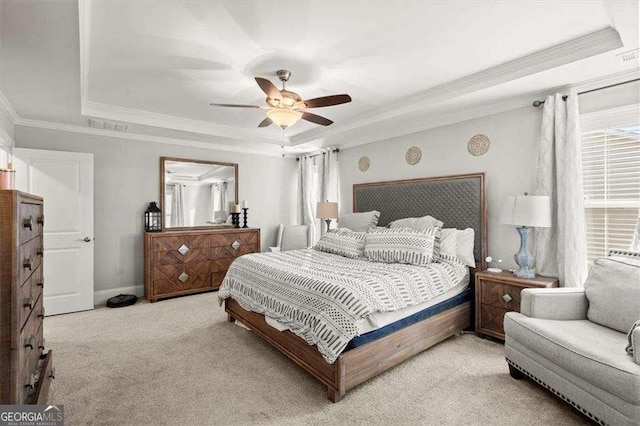 bedroom with ceiling fan, light colored carpet, crown molding, and a tray ceiling