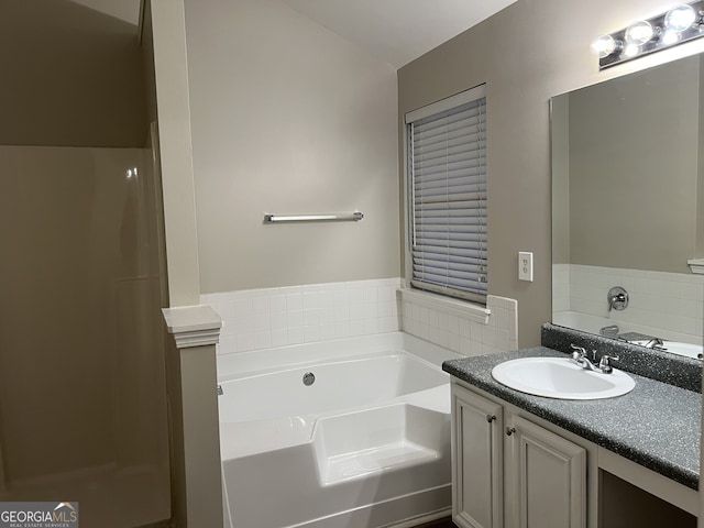 bathroom featuring vanity and a washtub