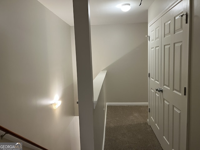 hall featuring dark colored carpet