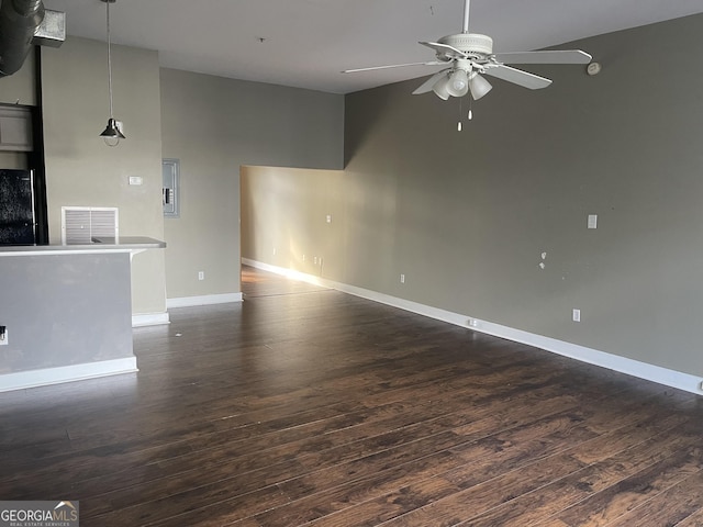 unfurnished living room featuring dark wood-type flooring and ceiling fan