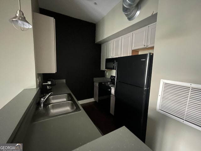 kitchen featuring decorative light fixtures, white cabinetry, sink, and black appliances