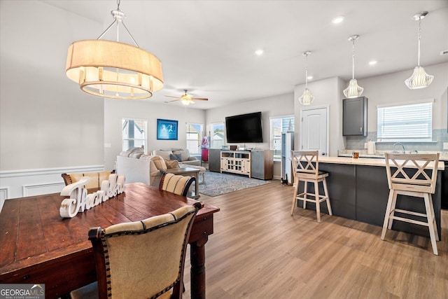 dining room with ceiling fan and light wood-type flooring