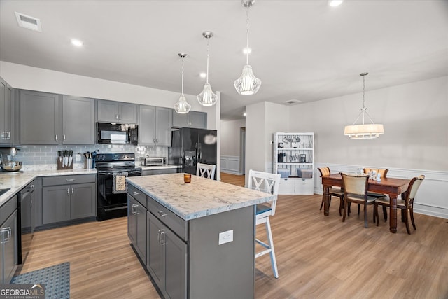 kitchen featuring gray cabinets, a center island, and black appliances