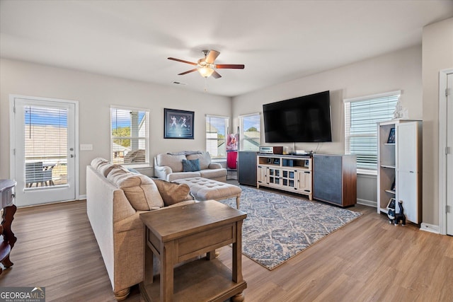 living room featuring wood-type flooring and ceiling fan