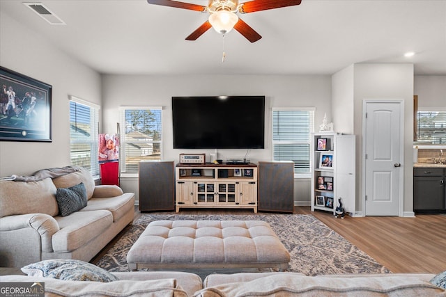 living room featuring wood-type flooring and ceiling fan