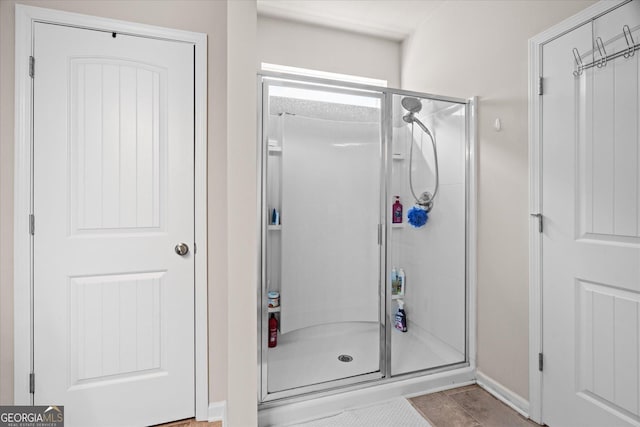 bathroom with a shower with door and tile patterned flooring