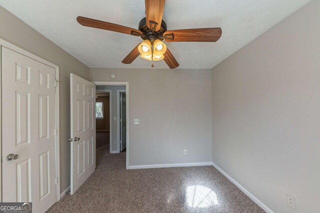 unfurnished bedroom with light colored carpet, a textured ceiling, and ceiling fan