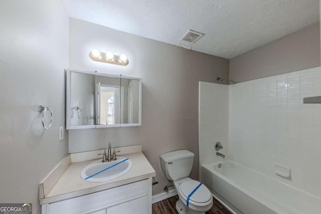 full bathroom featuring hardwood / wood-style flooring,  shower combination, toilet, a textured ceiling, and vanity