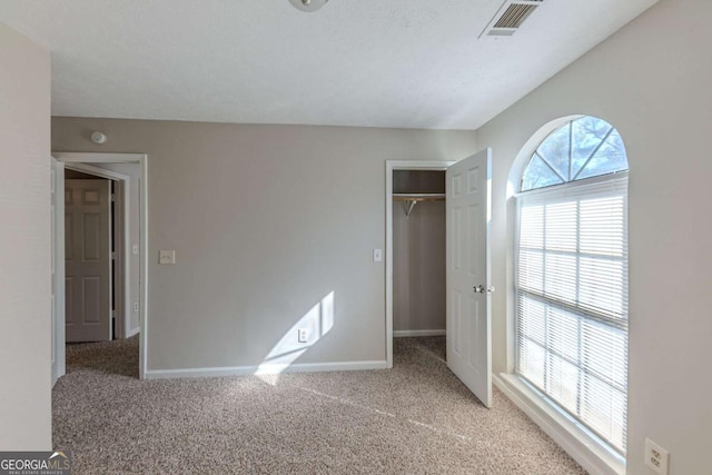 unfurnished bedroom featuring a closet and light carpet