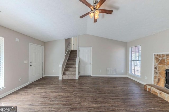 unfurnished living room featuring a fireplace, ceiling fan, dark hardwood / wood-style floors, and lofted ceiling