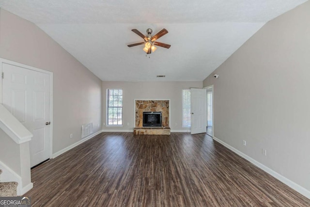 unfurnished living room with vaulted ceiling, ceiling fan, dark hardwood / wood-style flooring, a fireplace, and a textured ceiling