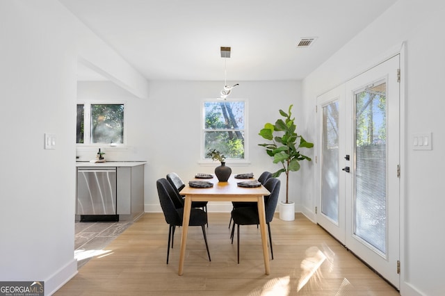 dining space featuring light wood-type flooring and french doors