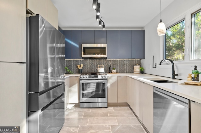 kitchen featuring stainless steel appliances, decorative backsplash, sink, hanging light fixtures, and gray cabinets