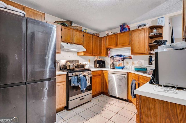 kitchen featuring sink, a textured ceiling, stainless steel appliances, and light tile patterned flooring