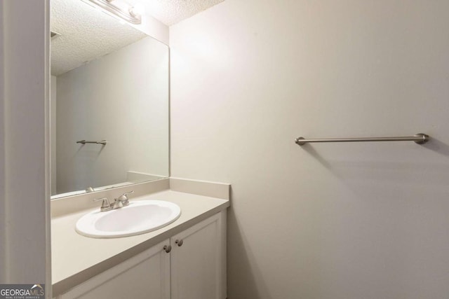 bathroom featuring a textured ceiling and vanity