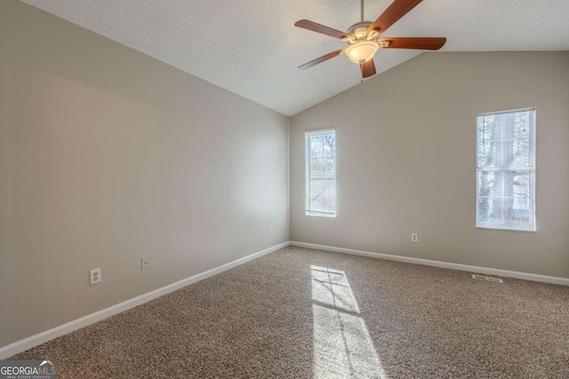 carpeted spare room with ceiling fan, a textured ceiling, and lofted ceiling